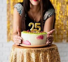 Mujer en vestido de fiesta negro listo para comer pastel de cumpleaños foto