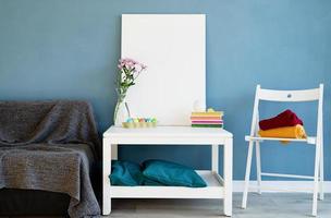 Mock up white poster frame on coffee table in blue room photo