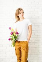 Young woman wearing blank white t-shirt holding tulips flowers photo