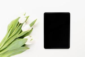 tulip flowers and mock up digital tablet top view flat lay photo