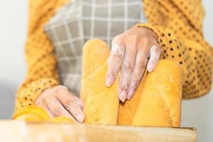 Mano sujetando un cubo de pan fresco en la panadería