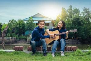 Family couple playing guitar in garden at home photo