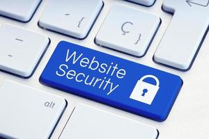 Website Security word and padlock icon on blue computer keyboard photo