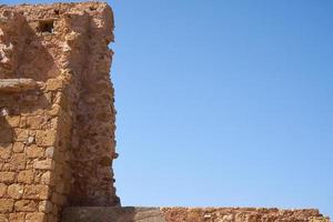 An old brick wall with clear blue sky in the background. photo