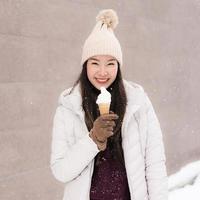 asian woman smile and happy with ice cream in snow winter season photo