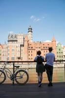 pareja de viajeros en gdansk con bicicleta retro