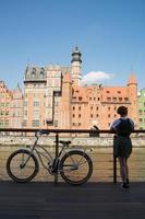 Mujer joven con bicicleta en el río en Gdansk foto