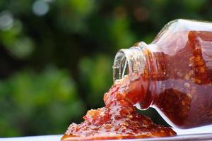 Close up chilli sauce on table, macro chilli sauce photo