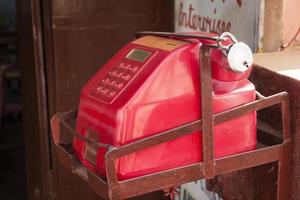 The big red telephone on the metal stand closed to a padlock in India photo