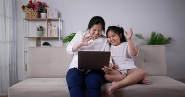 madre e hija pequeña videollamada en la computadora portátil video