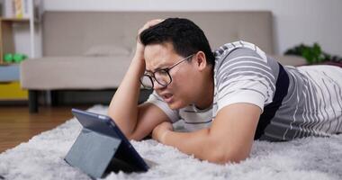 Upset Father Laying on Carpet with Video Call on Tablet