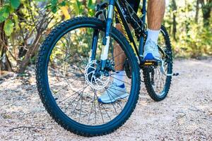 A perspective of cyclists on a rocky path focusing on car wheels. photo