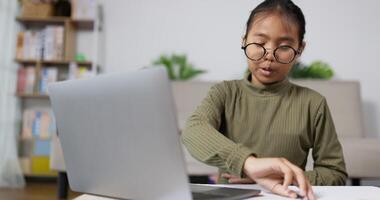 niña hablando y estudiando en línea con un portátil en la sala de estar video