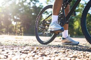 Una baja perspectiva de los ciclistas de montaña en un camino rocoso se centran en los zapatos foto