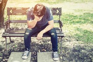 Headache man sitting on bench. photo