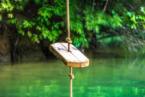 rope swing over clear water lake in mountains photo