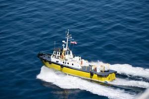 Barco piloto que conduce gran barco a través de las aguas. foto