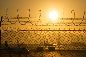 Valla de seguridad alrededor del aeropuerto internacional al amanecer. foto