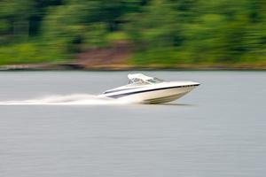 abstract blur of nature and fast moving boat on lake photo