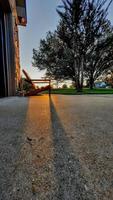 hermosa puesta de sol con sombras de silla adirondack cerca de la casa foto