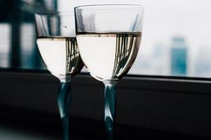 Two glasses of white wine on the window sill, beautiful reflections photo