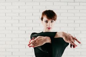 Pretty woman in black dress, dancing with red castanets, high key photo