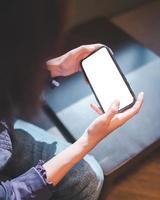 Young woman using smartphone with blank screen mockup photo