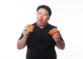 Hombre asiático gordo comiendo pizza hawaiana y de queso foto