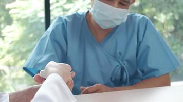 kvinnlig läkare undersöker blodet från en manlig patient för laboratorium. video