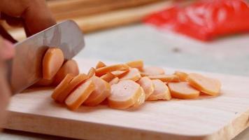 Close-up of woman's hand holding a knife cutting sausages. video