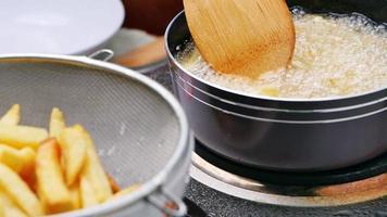 freír patatas fritas en la freidora en aceite caliente. video