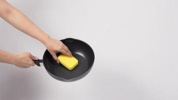 Man hand on white background cleaning the non stick pan photo