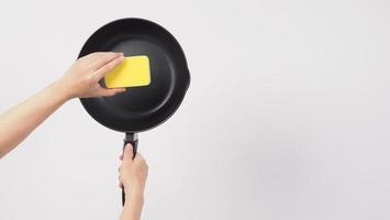 Man hand on white background cleaning the non stick pan photo