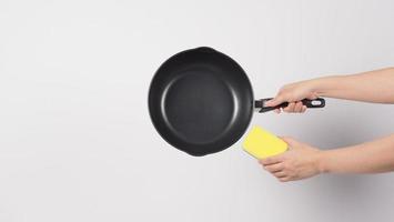 Man hand on white background cleaning the non stick pan photo