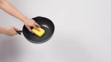 Man hand on white background cleaning the non stick pan photo