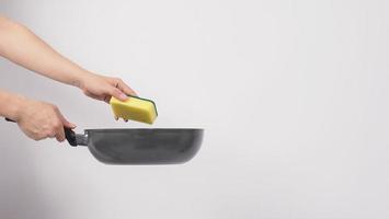 Man hand on white background cleaning the non stick pan photo