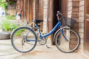 Bicicleta vieja delante de la pared de madera en casa foto