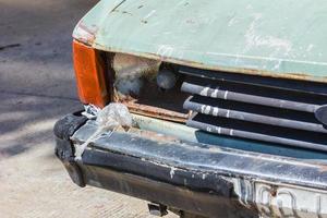 Close up shot of a junked car left in a car park photo