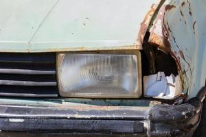 Close up shot of a junked car left in a car park photo