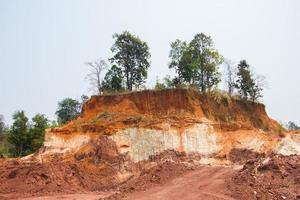 Layer of soil Front loader strips all side of a hill photo