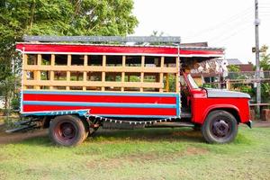 side view of red vintage truck on the ground photo