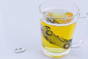 horizontal photo of toy car in a glass of beer isolated