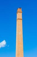 Old brick chimney on the background of clear  blue sky