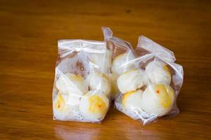 Traditional Chinese cake in plastic bag on wooden background. photo