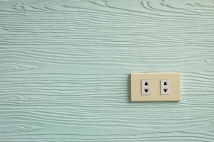 Wall outlets on the pale green wall with wood texture photo