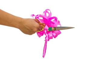 mans hand cutting something with scissors and pink bow photo