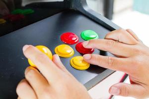 Manos de primer plano presionando y sosteniendo el joystick del antiguo videojuego arcade