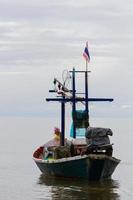 Barco de pesca con bandera tailandesa flotando en el mar