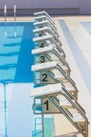 una fila de bloques de salida de la piscina en el borde de la piscina. vertical foto