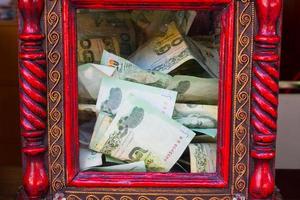 Thai money in red donation box in temple. photo